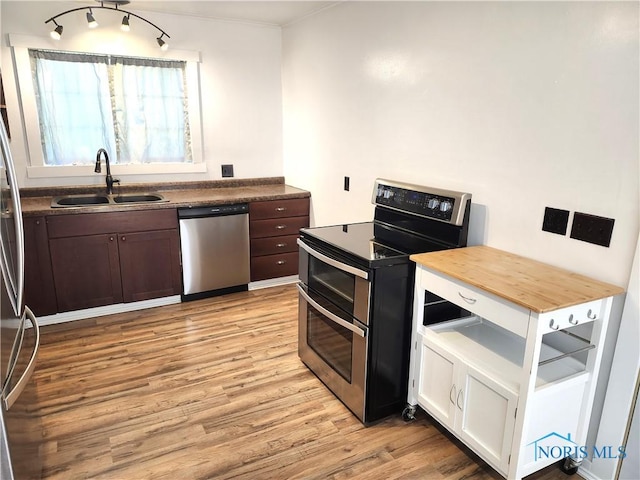 900 Leonard St, Fostoria, OH 44830 - kitchen with appliances with stainless steel finishes, a sink, light wood-type flooring, butcher block countertops, and dark brown cabinets