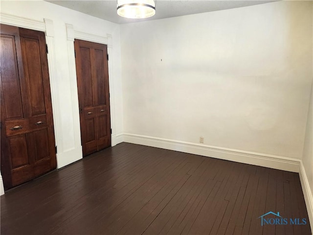 900 Leonard St, Fostoria, OH 44830 - unfurnished bedroom featuring baseboards, dark wood finished floors, and a closet