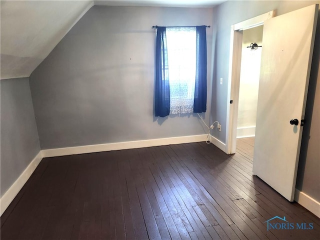 900 Leonard St, Fostoria, OH 44830 - additional living space featuring dark wood-style floors, vaulted ceiling, and baseboards