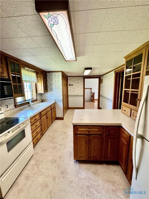 211 S Keyser St, Holgate, OH 43527 - kitchen featuring white appliances, wallpapered walls, a peninsula, a sink, and light countertops