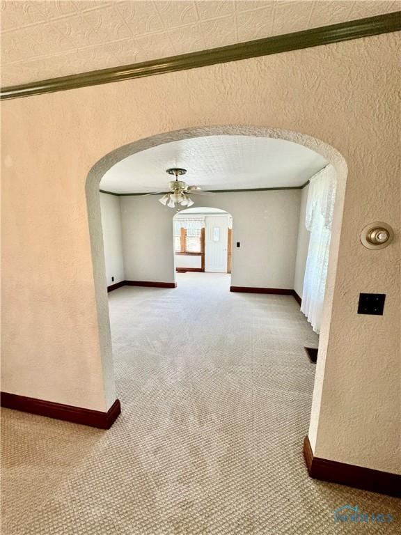 211 S Keyser St, Holgate, OH 43527 - carpeted spare room with arched walkways, a textured wall, a ceiling fan, and baseboards