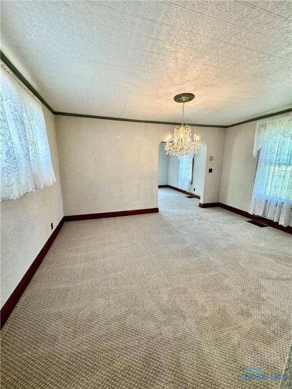211 S Keyser St, Holgate, OH 43527 - empty room featuring a chandelier, light carpet, baseboards, and ornamental molding