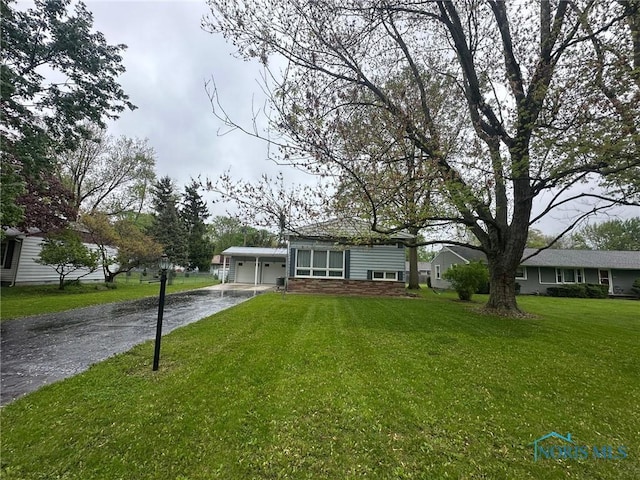 view of front of house with driveway, an attached garage, and a front yard