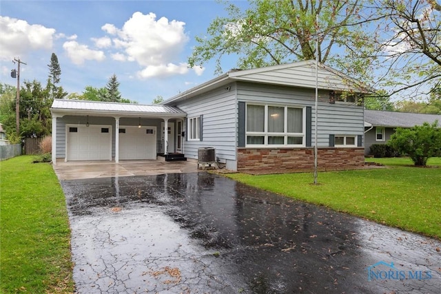 1639 Brookside Dr, Findlay, OH 45840 - view of front of property featuring stone siding, an attached garage, and asphalt driveway