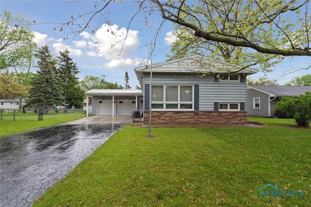 1639 Brookside Dr, Findlay, OH 45840 - back of property featuring a garage, asphalt driveway, and central air condition unit