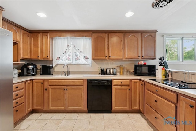 1639 Brookside Dr, Findlay, OH 45840 - kitchen with black appliances, a sink, light countertops, light tile patterned floors, and brown cabinets