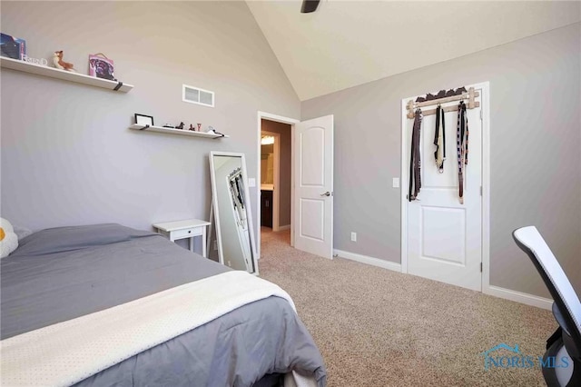 bedroom with vaulted ceiling, light colored carpet, and baseboards