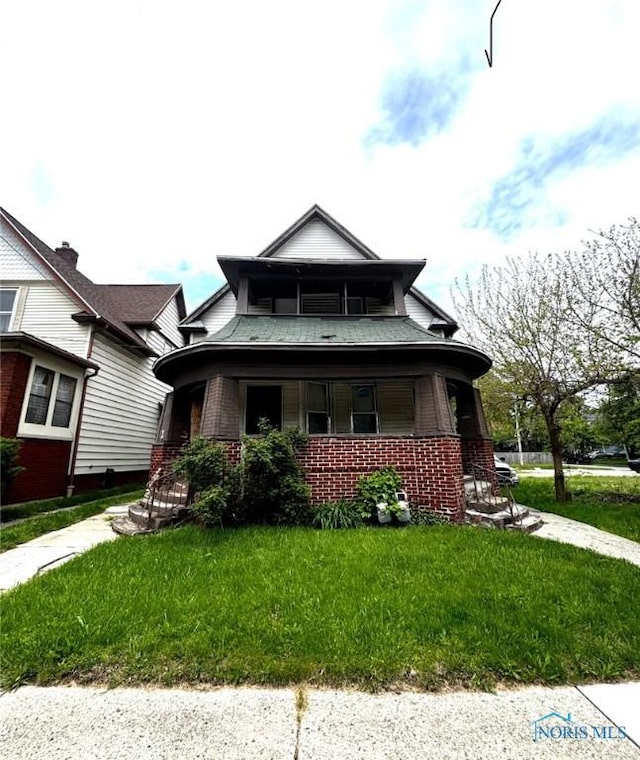 bungalow featuring brick siding, a porch, and a front lawn
