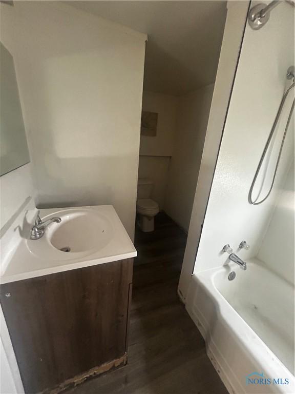 1566 Western Ave, Toledo, OH 43609 - bathroom with toilet, wood finished floors, vanity, and washtub / shower combination