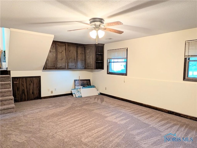1270 S Park Ln, Wauseon, OH 43567 - carpeted empty room featuring a ceiling fan, baseboards, stairway, and a textured ceiling