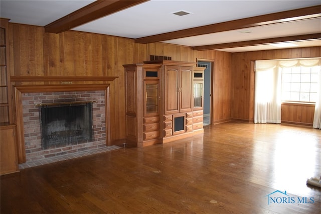 1527 S Ct, Findlay, OH 45840 - unfurnished living room featuring a fireplace, beamed ceiling, wood finished floors, and wooden walls