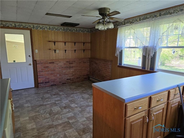 23423 Rd 104, Oakwood, OH 45873 - kitchen with ceiling fan, wooden walls, a baseboard radiator, brown cabinets, and light countertops