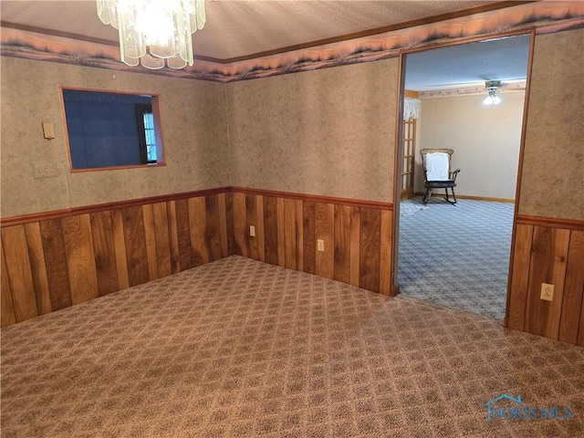 23423 Rd 104, Oakwood, OH 45873 - carpeted spare room featuring a chandelier, wood walls, and wainscoting