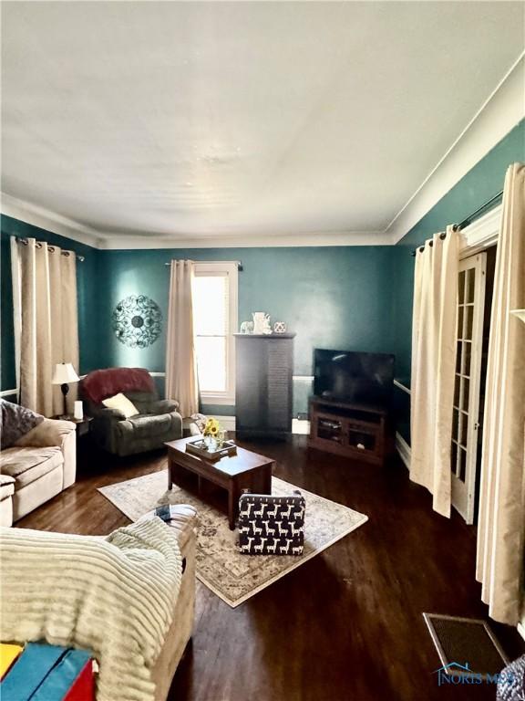 living room featuring wood finished floors and crown molding