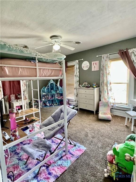 carpeted bedroom with a textured ceiling and a ceiling fan