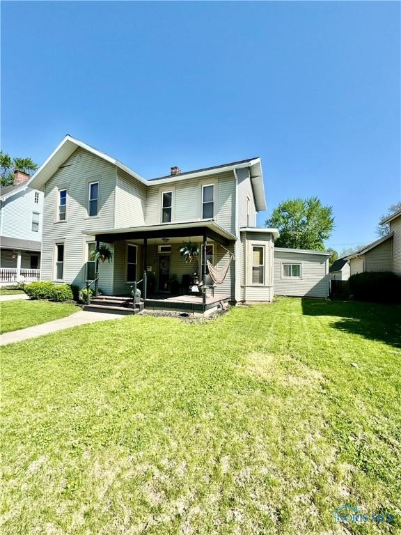 rear view of property with a lawn and a chimney
