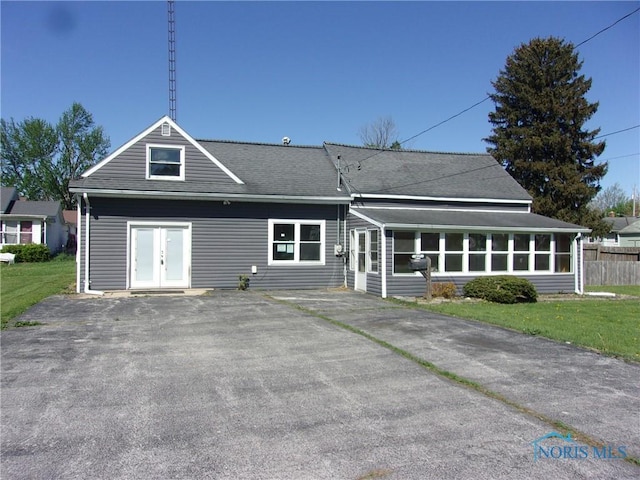 417 Race St, Clyde, OH 43410 - rear view of house featuring french doors, a sunroom, a lawn, and a shingled roof