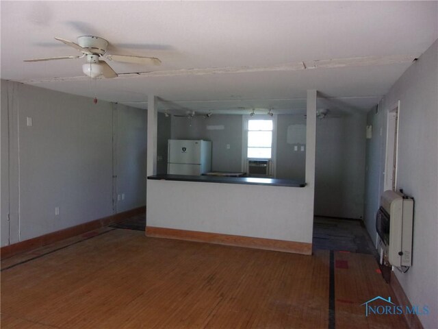 417 Race St, Clyde, OH 43410 - unfurnished living room with heating unit, wood finished floors, ceiling fan, and baseboards