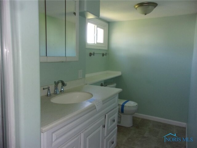 417 Race St, Clyde, OH 43410 - half bathroom featuring vanity, toilet, and baseboards