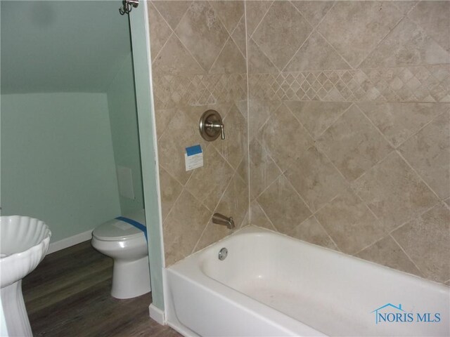 417 Race St, Clyde, OH 43410 - full bathroom featuring baseboards, toilet, wood finished floors, and washtub / shower combination