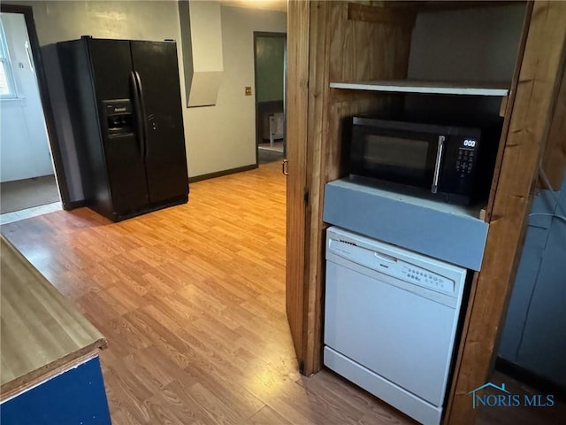 215 E Bryan St, Bryan, OH 43506 - kitchen featuring black appliances, light wood-type flooring, and baseboards