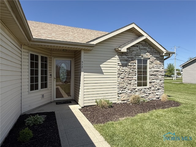 512 Fugate Dr, Defiance, OH 43512 - property entrance featuring stone siding, a lawn, and roof with shingles