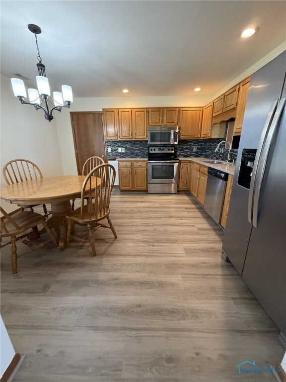 512 Fugate Dr, Defiance, OH 43512 - kitchen featuring stainless steel appliances, a chandelier, a sink, backsplash, and pendant lighting