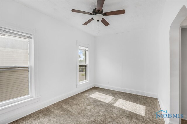 308 Crittenden Ave, Toledo, OH 43609 - empty room featuring arched walkways, carpet flooring, ceiling fan, and baseboards