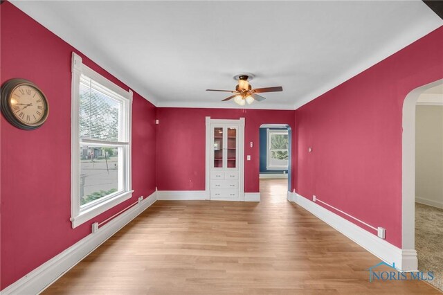 308 Crittenden Ave, Toledo, OH 43609 - empty room featuring arched walkways, a ceiling fan, baseboards, and wood finished floors
