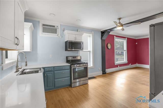 308 Crittenden Ave, Toledo, OH 43609 - kitchen featuring stainless steel appliances, a sink, a ceiling fan, a wall mounted air conditioner, and white cabinets