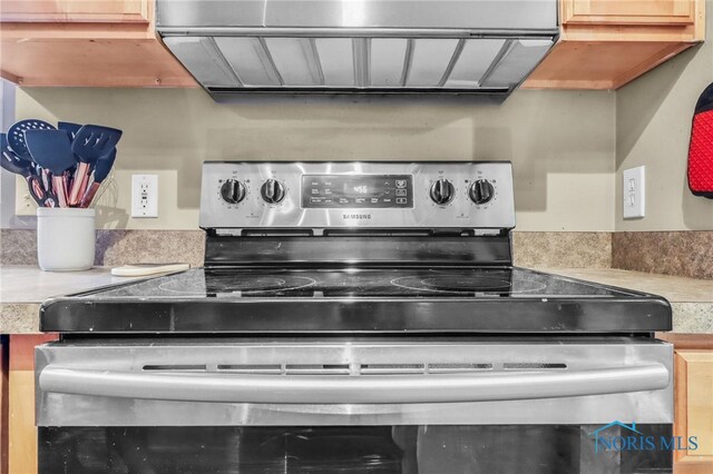 5956 E Pembridge Dr, Toledo, OH 43615 - kitchen view of electric range, extractor fan, and light countertops