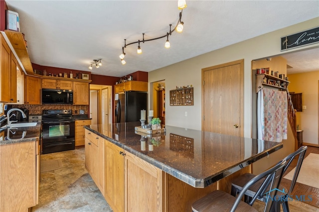 8012 County Highway 55, Upper Sandusky, OH 43351 - kitchen with black appliances, a sink, tasteful backsplash, a kitchen island, and a kitchen bar