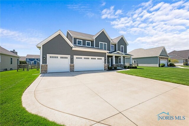 9575 Newbury Ln, Whitehouse, OH 43571 - craftsman house with concrete driveway, stone siding, covered porch, and a garage