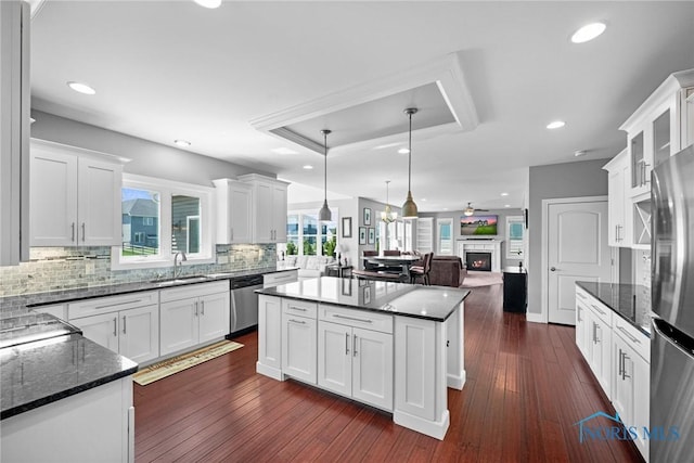 9575 Newbury Ln, Whitehouse, OH 43571 - kitchen with stainless steel appliances, a kitchen island, decorative backsplash, open floor plan, and white cabinetry