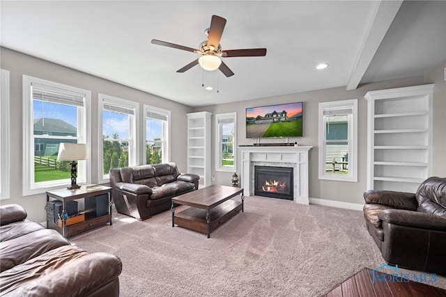 9575 Newbury Ln, Whitehouse, OH 43571 - carpeted living room with a ceiling fan, a glass covered fireplace, baseboards, built in shelves, and recessed lighting