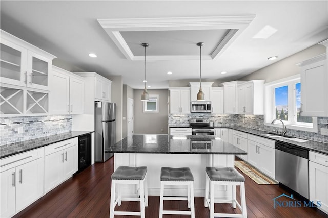 9575 Newbury Ln, Whitehouse, OH 43571 - kitchen featuring appliances with stainless steel finishes, a tray ceiling, wine cooler, decorative backsplash, and recessed lighting