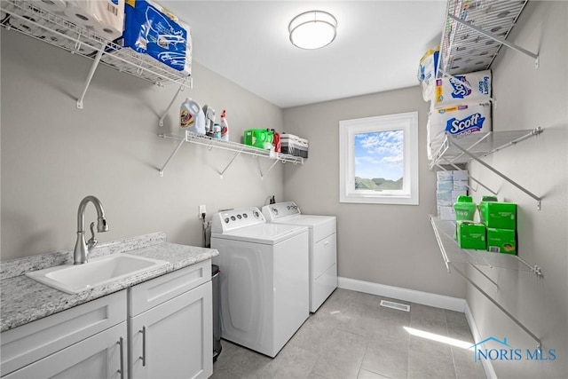 9575 Newbury Ln, Whitehouse, OH 43571 - laundry room with washer and dryer, baseboards, light tile patterned floors, and cabinet space