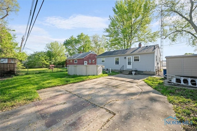 back of property featuring entry steps, an outdoor structure, and a storage unit