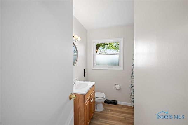 full bath featuring wood finished floors, toilet, vanity, and baseboards