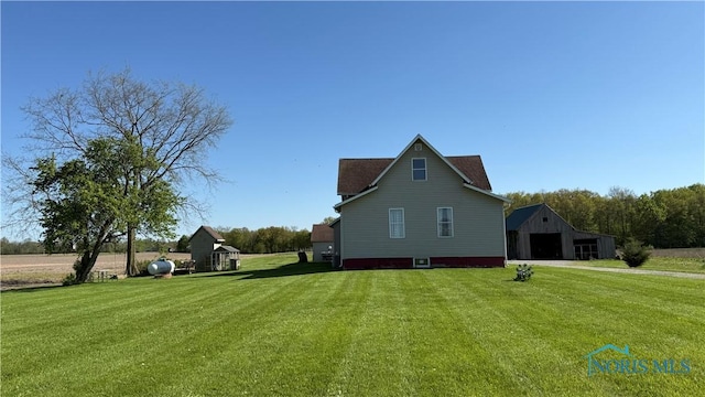 16820 Gipe Rd, Ney, OH 43549 - view of side of home featuring a detached garage, a lawn, and an outdoor structure