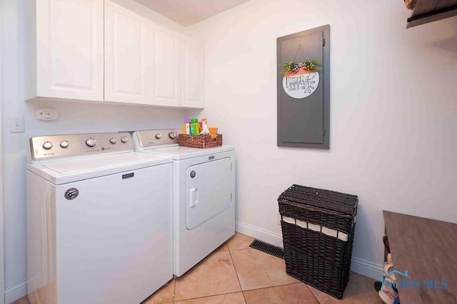2057 Windsor Pl, Findlay, OH 45840 - clothes washing area with washer and dryer, cabinet space, baseboards, and light tile patterned flooring