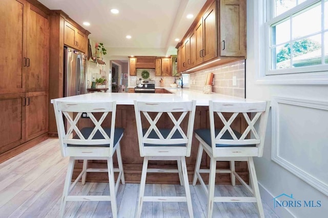 2057 Windsor Pl, Findlay, OH 45840 - kitchen featuring stainless steel appliances, brown cabinets, light countertops, a peninsula, and recessed lighting