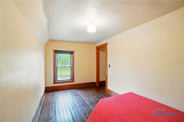 7438 Yawberg Rd, Whitehouse, OH 43571 - unfurnished bedroom featuring dark wood-type flooring, baseboards, and vaulted ceiling