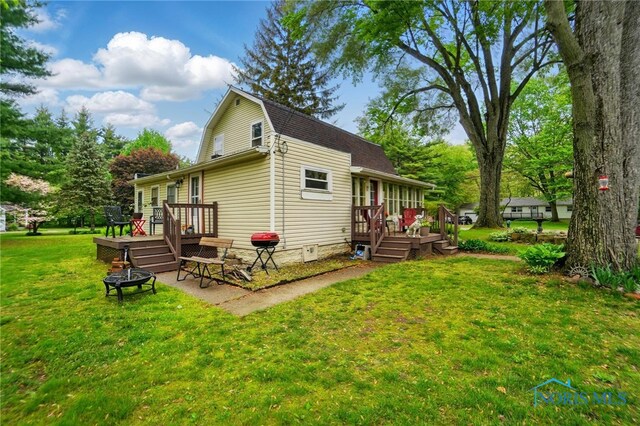 7438 Yawberg Rd, Whitehouse, OH 43571 - rear view of property with a wooden deck, a yard, a fire pit, and a gambrel roof