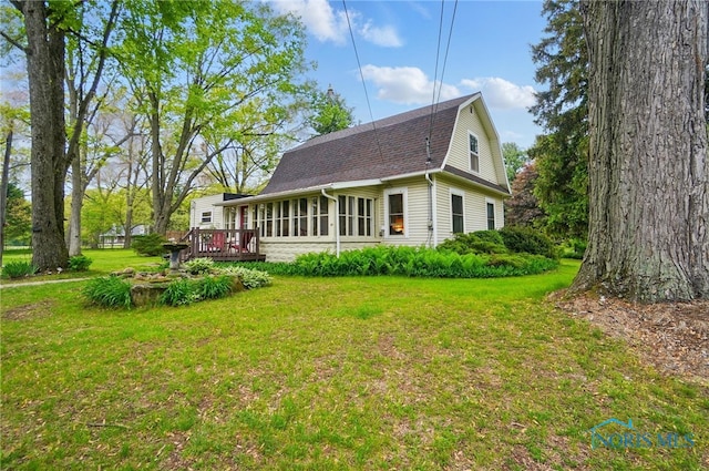 7438 Yawberg Rd, Whitehouse, OH 43571 - view of home's exterior featuring a gambrel roof, a wooden deck, a lawn, and a shingled roof