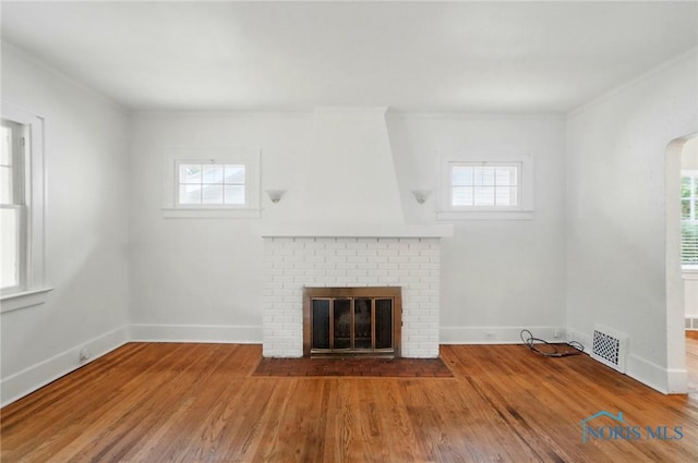 4315 Eastway St, Toledo, OH 43612 - unfurnished living room with plenty of natural light, wood finished floors, a brick fireplace, and ornamental molding