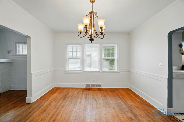 4315 Eastway St, Toledo, OH 43612 - unfurnished dining area featuring arched walkways, light wood-style floors, healthy amount of natural light, ornamental molding, and a chandelier
