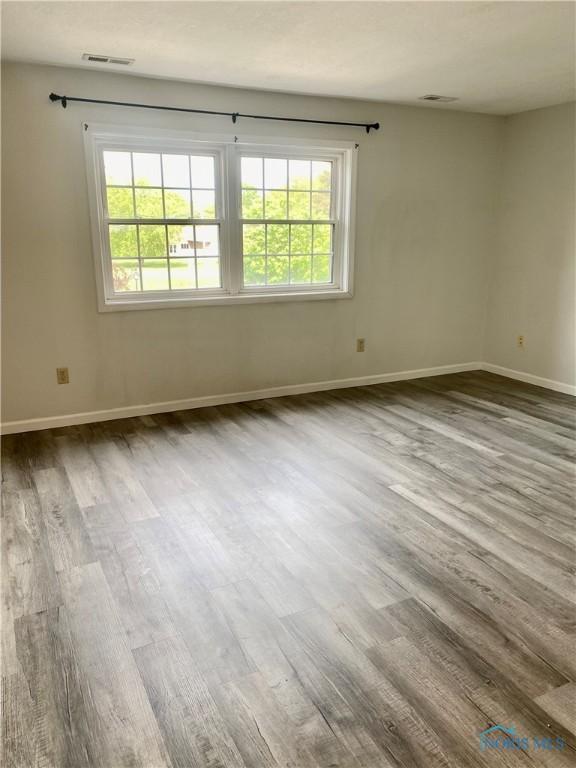 4730 Glendale Ave Unit 206, Toledo, OH 43614 - empty room with dark wood-style flooring, plenty of natural light, and baseboards