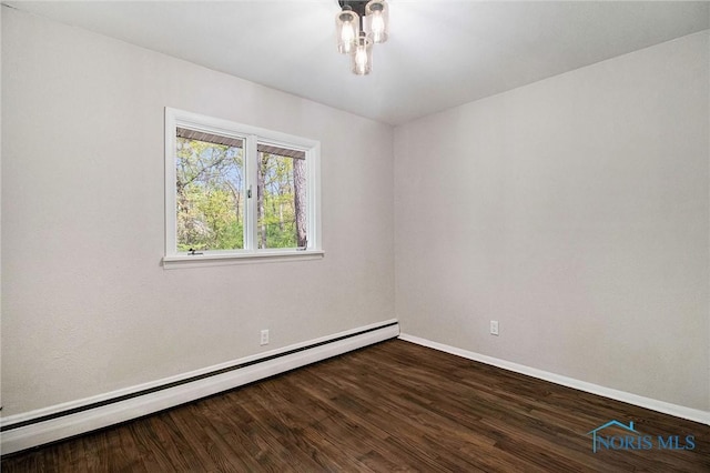 unfurnished room featuring baseboard heating, baseboards, and wood finished floors