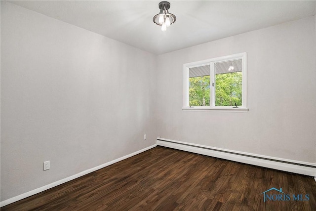spare room with a baseboard radiator, wood finished floors, and baseboards